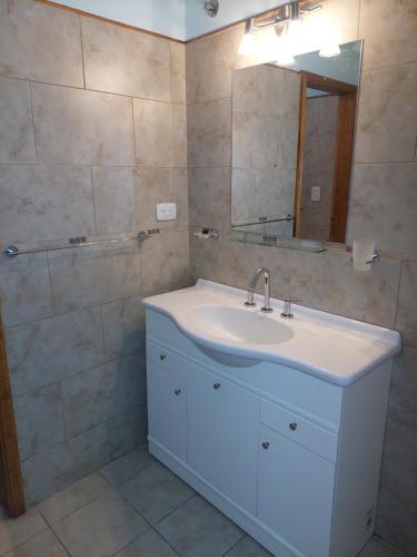 a bathroom with a white sink and a mirror at Casa de Cande in Tandil