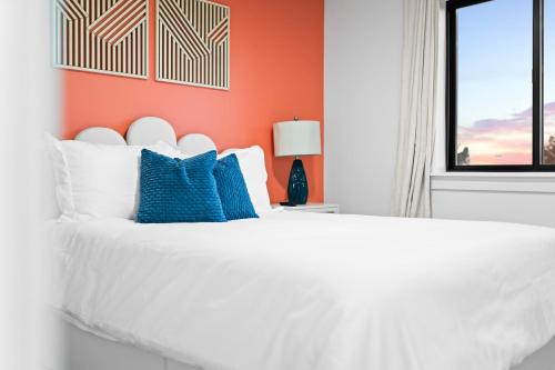 a white bed with blue pillows in a bedroom at Luxe Desert Retreat - Near Grand Canyon South Rim in Valle