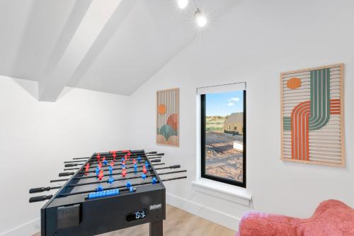 a room with a foosball table in front of a window at Luxe Desert Retreat - Near Grand Canyon South Rim in Valle