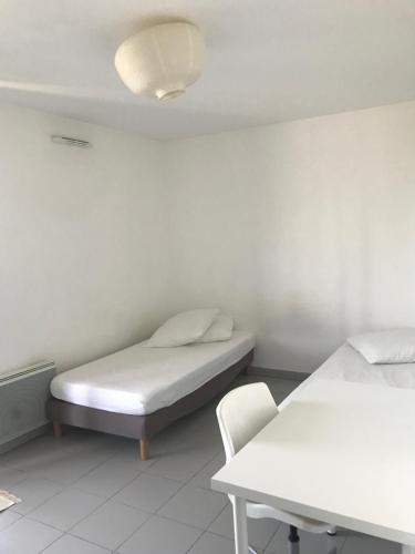une chambre d'hôpital avec deux lits et une chaise dans l'établissement Résidence le Carré Saint Roch, à Montpellier