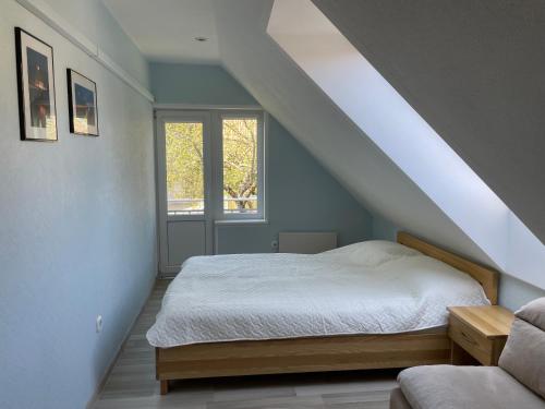 a bedroom with a bed and a window at Neringaholiday Apartamentai in Juodkrantė