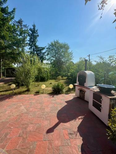 a outdoor kitchen with a grill on a brick patio at Extra House in Balatonvilágos