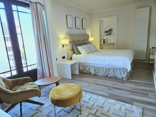 a bedroom with a bed and a couch and a chair at Lazy Olives in Tongeren