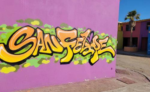 a pink wall with some graffiti on it at InTown Beach front condo - Casey`s condo 1 in San Felipe