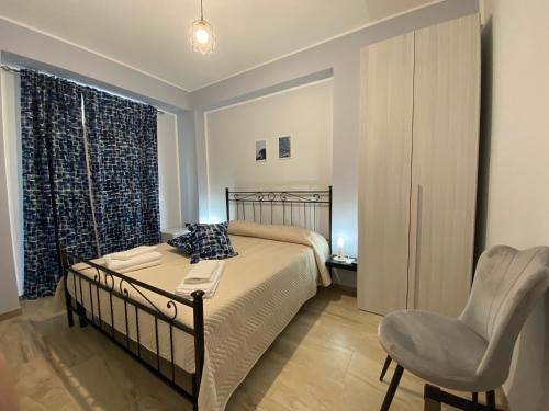 a bedroom with a bed and a chair and a window at Il Giardino delle Rose in Praia a Mare