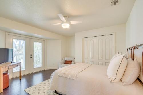 a bedroom with a bed with a ceiling fan and a desk at Private Beach at Lakefront Summerfield Getaway! in Summerfield