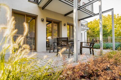 a patio with chairs and a table with a dog on it at Vendégház a Tábornokhoz in Visegrád