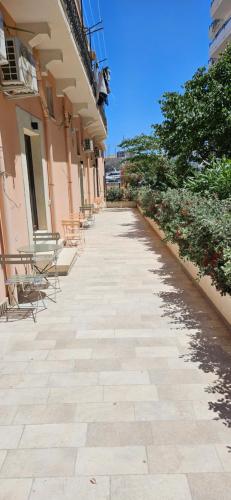 a stone walkway with chairs and a building at Eos - Elegants Apartments & Suites in Siracusa