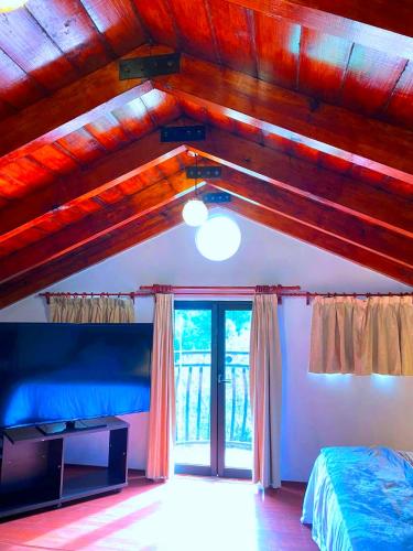 a bedroom with a bed and a large window at Alojamiento tipo Cabaña, rodeado de Bosque in Mexico City