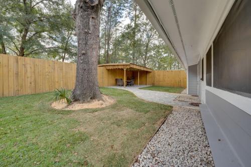 a house with a tree next to a fence at Apopka Home with Yard and Grill Near Wekiwa Springs! in Apopka