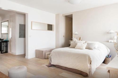 - une chambre blanche avec un grand lit et un canapé dans l'établissement Magnifique Loft 65m en Open Space, à Paris