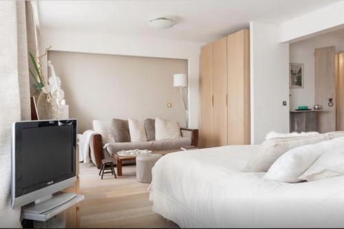 une chambre avec un lit, une télévision et un canapé dans l'établissement Magnifique Loft 65m en Open Space, à Paris