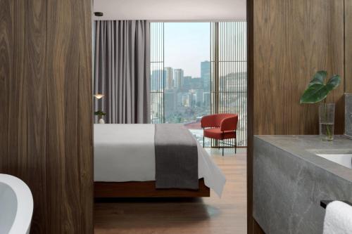 a bedroom with a bed and a view of a city at Presidente InterContinental Monterrey by IHG in Monterrey