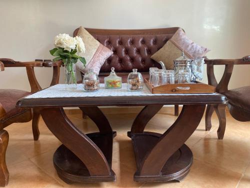 una mesa de café de madera con un jarrón de flores. en calm and secure residence with pool, en Sidi Bouzid