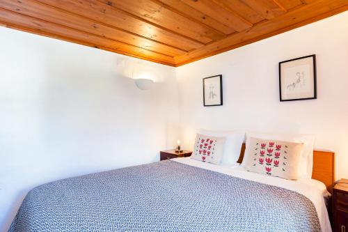 a white bedroom with a bed and wooden ceilings at Village House in Sintra hills in Colares