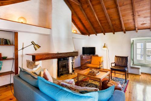 a living room with a blue couch and a fireplace at Village House in Sintra hills in Colares