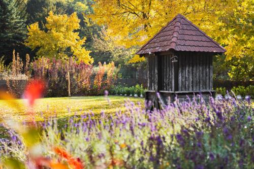 a wooden gazebo in a garden with purple flowers at Vendégház a Tábornokhoz in Visegrád