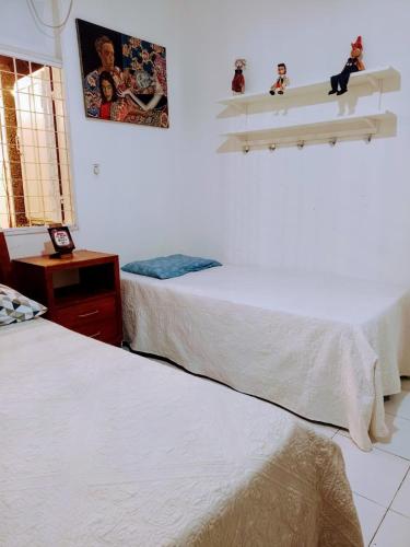 a bedroom with two beds and a picture on the wall at Pousada Morada Bonfim in Olinda