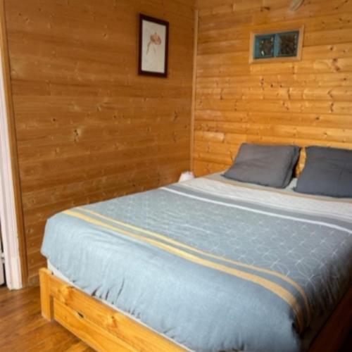 une chambre avec un lit dans un mur en bois dans l'établissement Appartement, à Ax-les-Thermes