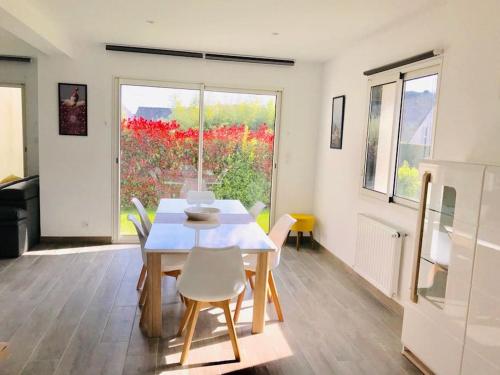 une salle à manger avec une table et des chaises et une fenêtre dans l'établissement Maison avec jacuzzi 10 personnes, à Locquénolé