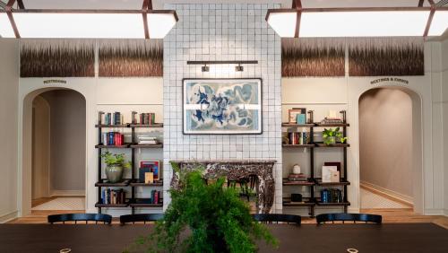 a room with a fireplace and shelves of books at Hotel Heron Old Town Alexandria in Alexandria