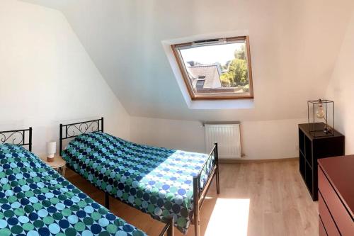 - une chambre mansardée avec 2 lits et une fenêtre dans l'établissement Maison avec jacuzzi 10 personnes, à Locquénolé