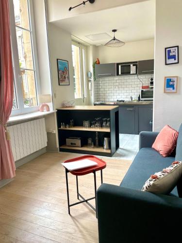 - un salon avec un canapé bleu et un tabouret rouge dans l'établissement Studio Cosy Le Bareuzai, à Dijon