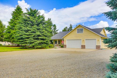 a house with a driveway and a tree at Moyie Springs Home with Views, Near Kootenay River! in Bonners Ferry