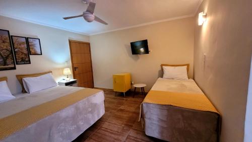 a bedroom with two beds and a ceiling fan at HOTEL ESTÂNCIA - ESTACIONAMENTO GRATUITO ROTATIVO - Vagas Limitadas in Poços de Caldas