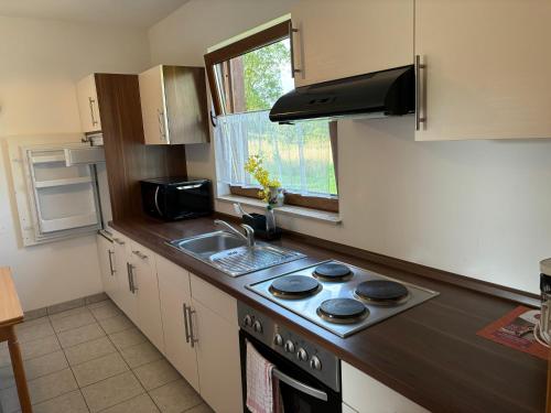 a kitchen with a stove and a sink and a window at Ferienwohnung Burg Katz in Lahnstein