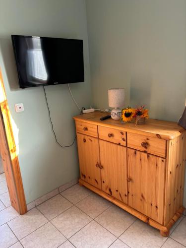 a television on a wall above a wooden dresser at Ferienwohnung Burg Katz in Lahnstein