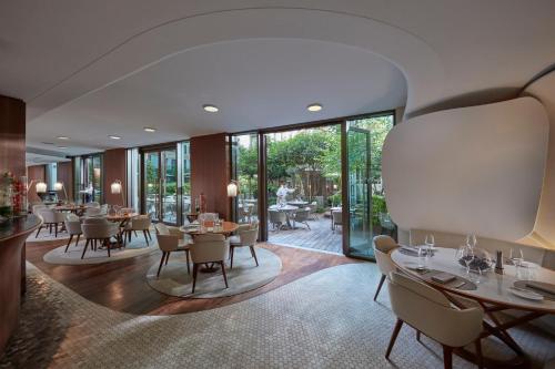 a dining room with tables and chairs and windows at Mandarin Oriental, Paris in Paris