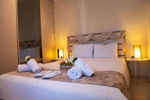 a bedroom with a large white bed with two towels at Ancient port house in Mytilini