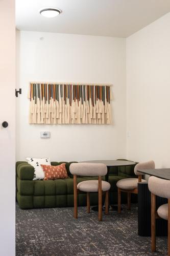 a living room with a green couch and chairs at Kinship Landing in Colorado Springs