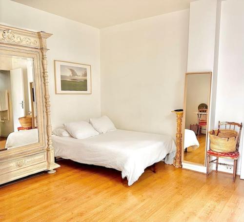 une chambre avec un lit et un grand miroir dans l'établissement Charming studio in a courtyard in Paris, à Paris