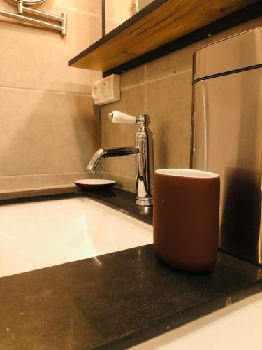 a coffee cup sitting on a counter next to a sink at Appartement très haut avec Piscine, sauna, salle de sport et solarium in Paris