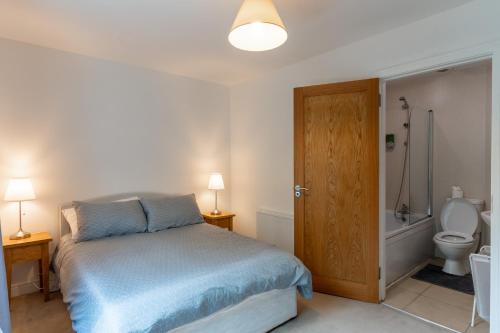 a bedroom with a bed and a bathroom with a toilet at Retreat in Tulfarris County Wicklow - Ireland in Blessington