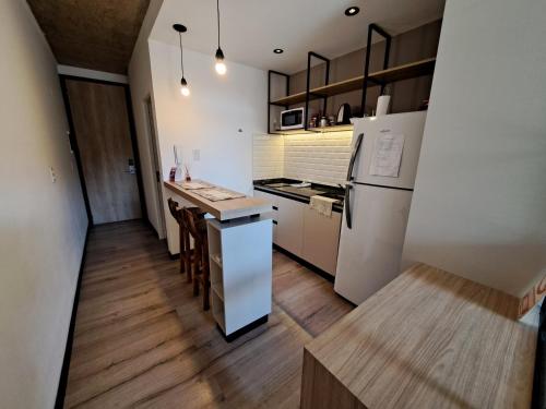 a kitchen with a white refrigerator and wooden floors at Departamento - Salta Capital cg - Edificio Usina in Salta