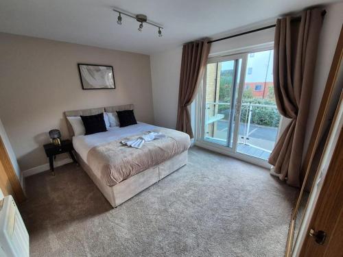 a bedroom with a bed and a large window at Contractors l FreeParking l Station l Students in Colchester