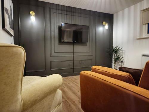 a living room with a couch and a flat screen tv at Contractors l FreeParking l Station l Students in Colchester