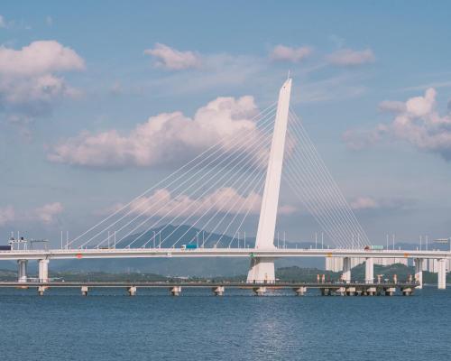 a bridge over the water with a cloudy sky at Crowne Plaza Shenzhen World Exhibition and Convention Center by IHG in Shenzhen