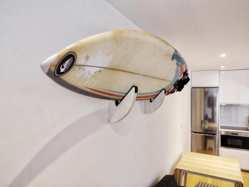 ein Surfbrett, das an einer Wand in einer Küche hängt in der Unterkunft Casa Náutica T1 Norte in Ovar