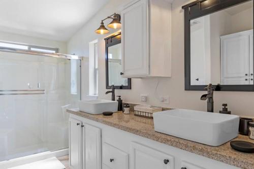 a white bathroom with two sinks and a shower at Five Points House with Amazing Views in Tehachapi