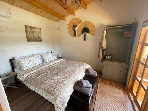 a bedroom with a bed and a dresser and a window at The Retreat - Oak Lodge in Corfu