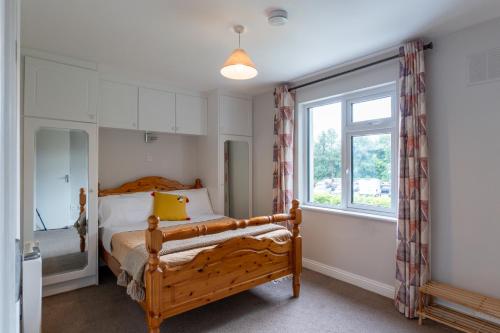 a bedroom with a bed and a window at Tully's Home, Tulfarris Village, Wicklow in Blessington