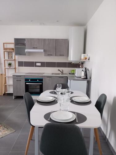 une cuisine avec une table avec des assiettes et des verres à vin dans l'établissement Com'cz soi, à Bourges