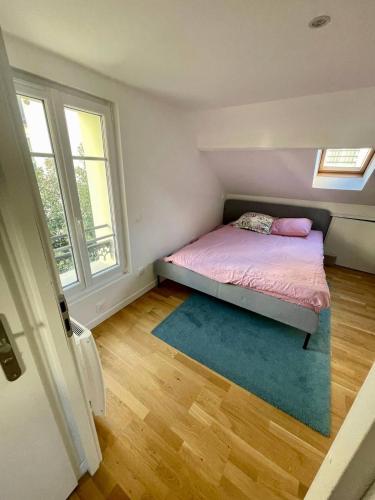 a small bedroom with a bed and two windows at Nice area 5 minutes from Paris in Suresnes
