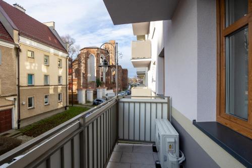 a balcony with a bench and a city street at Comfy Aparts Plac Solny II in Głogów