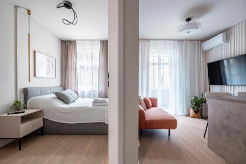 a bedroom with a bed and a tv and a chair at Comfy Aparts Plac Solny II in Głogów