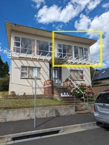 a house with a yellow frame in front of it at Bayley 2 - Walk to city from 2 bedroom apartment with city and mountain views in Hobart